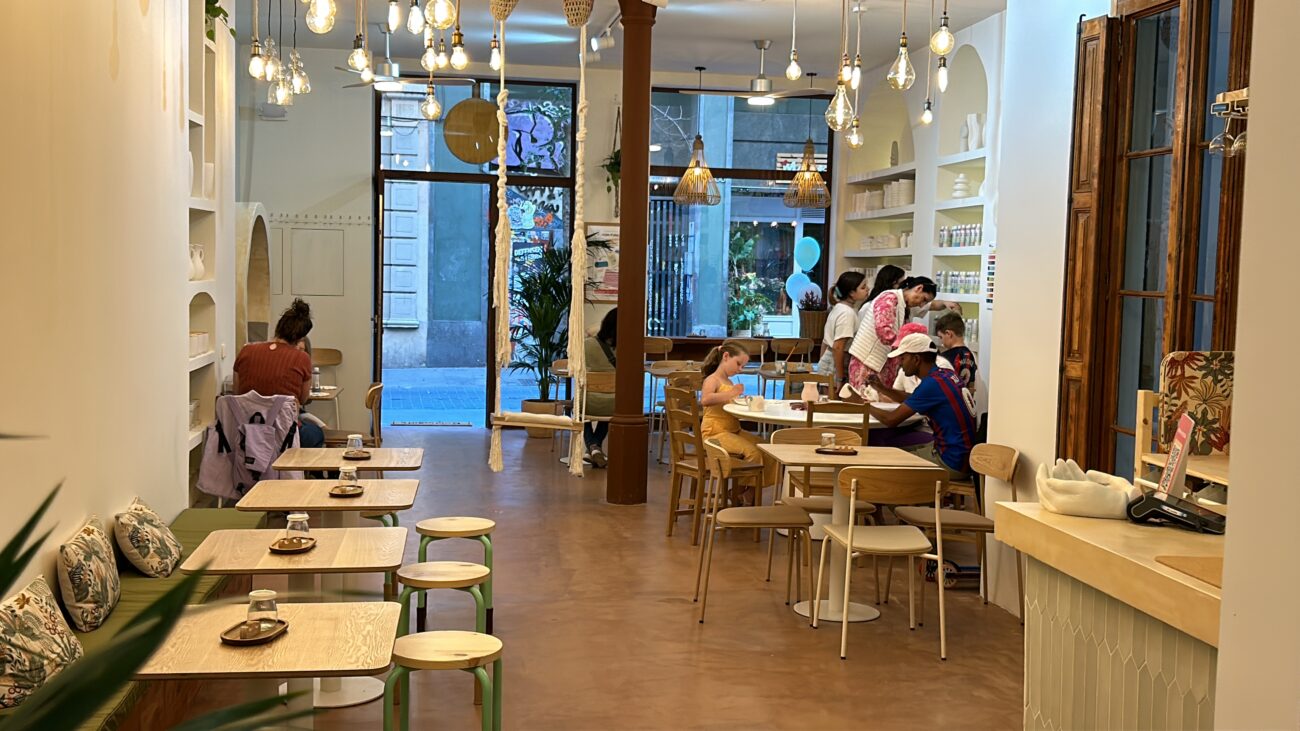 Experiència creativa a Barcelona: participants pintant ceràmica amb guia al taller